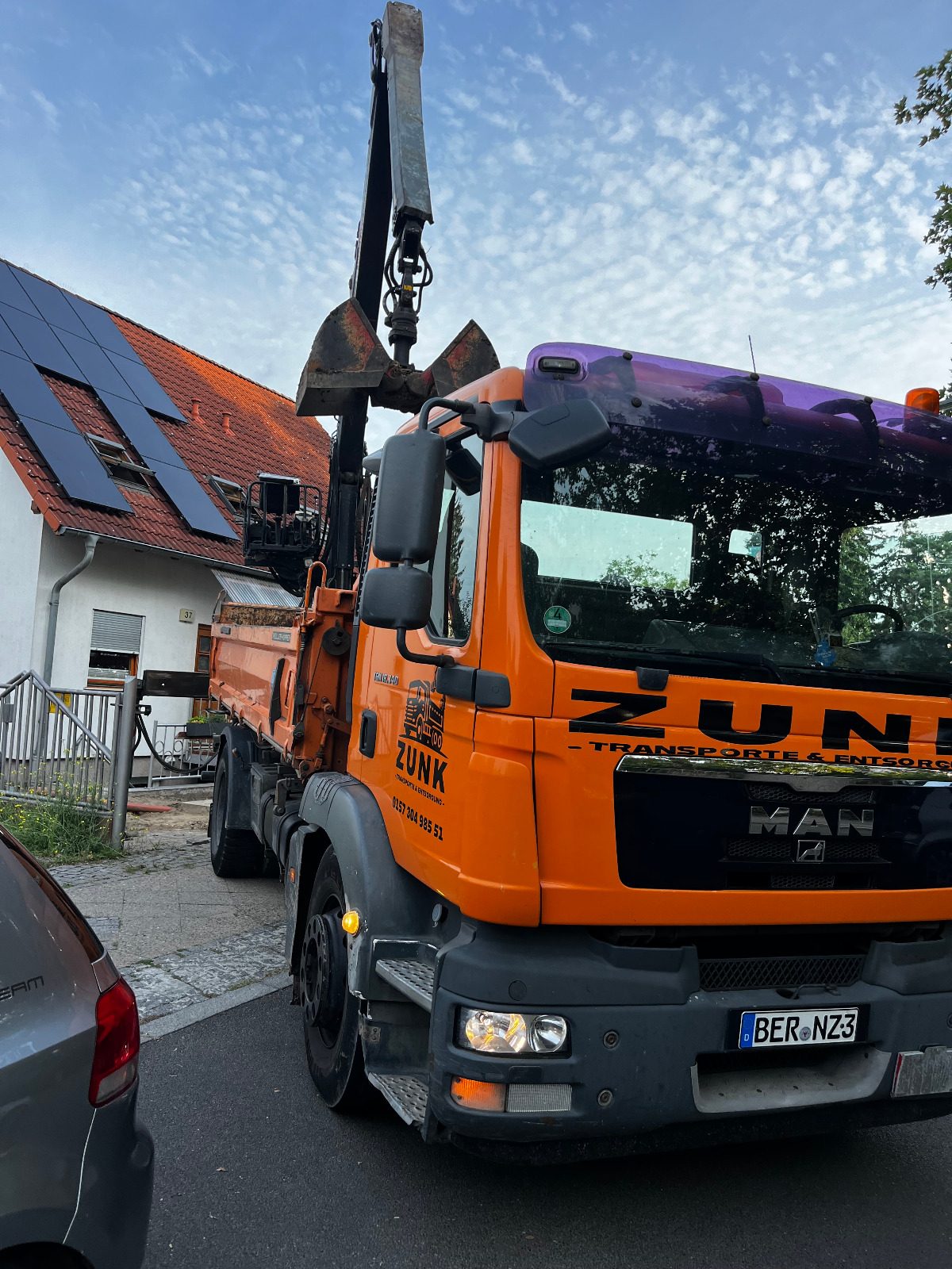 Zunk Transporte und Entsorgung – Fahrzeug im Einsatz Nahaufnahme eines Zunk-Transporte-und-Entsorgung-Fahrzeugs mit Ladekran
